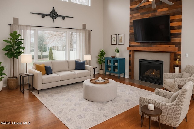 20 Fort Vaux Ln, Colonie, NY 12189 - living area featuring wood finished floors, ceiling fan, a fireplace with flush hearth, and a towering ceiling