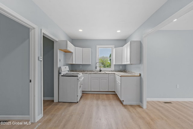 111 Mann Ave, Troy, NY 12180 - kitchen with gas range gas stove, a sink, baseboards, light wood-style floors, and white cabinetry