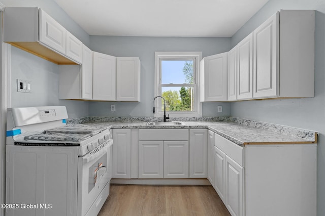111 Mann Ave, Troy, NY 12180 - kitchen featuring white cabinets, a sink, light countertops, light wood-style flooring, and white gas range