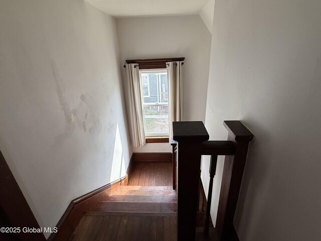 stairs with hardwood / wood-style floors, baseboards, and lofted ceiling