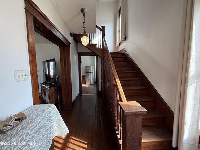 stairs with hardwood / wood-style floors and baseboards