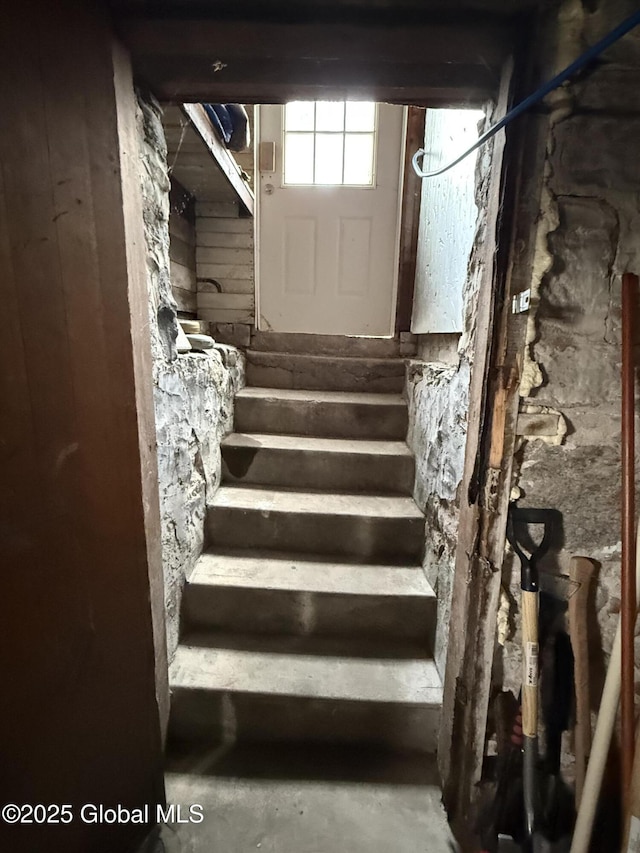 stairway with unfinished concrete flooring