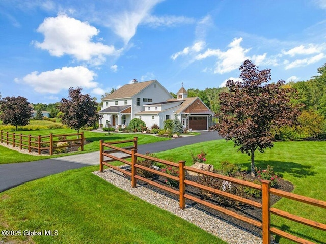 exterior space featuring a garage, fence, and a front lawn