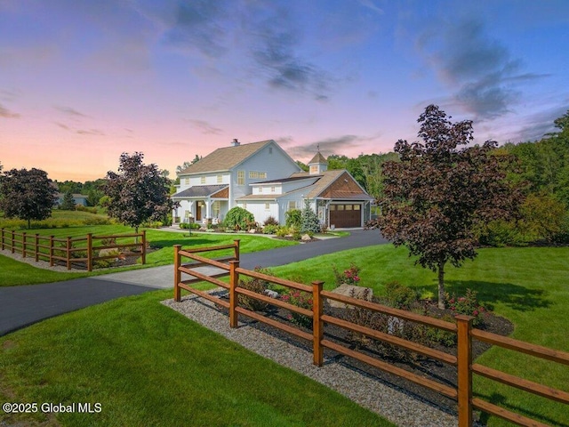 exterior space featuring fence, an attached garage, a yard, and driveway