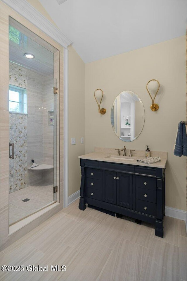 bathroom with vanity, baseboards, and a stall shower