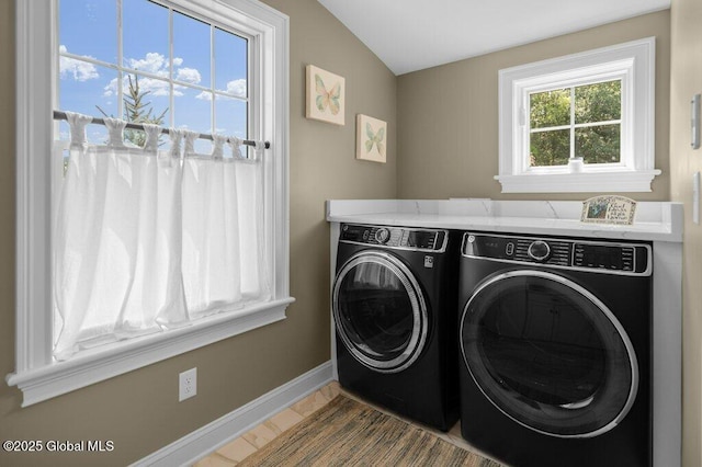 clothes washing area featuring baseboards, laundry area, and washing machine and dryer
