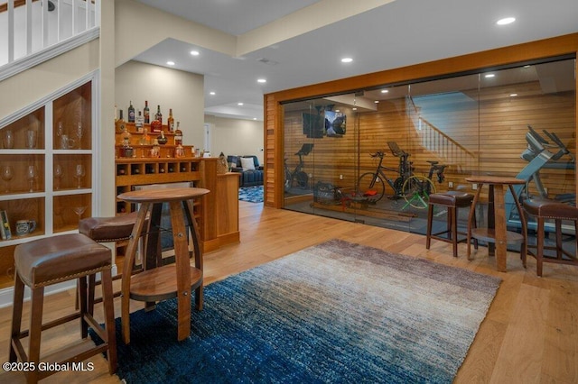 bar featuring wooden walls, recessed lighting, and wood finished floors