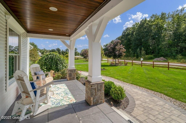 view of patio featuring fence and covered porch
