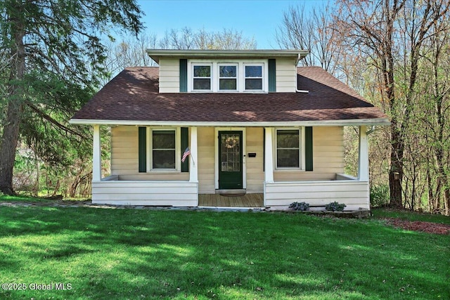 bungalow-style home with a shingled roof, a front lawn, and covered porch