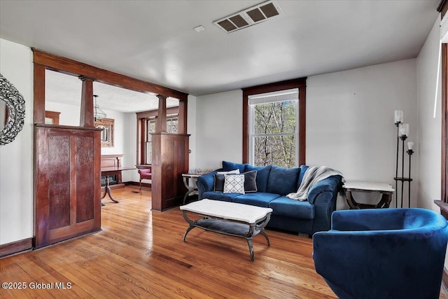 living room featuring visible vents, baseboards, and light wood-type flooring