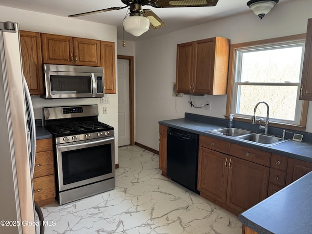 kitchen with ceiling fan, brown cabinets, a sink, marble finish floor, and stainless steel appliances