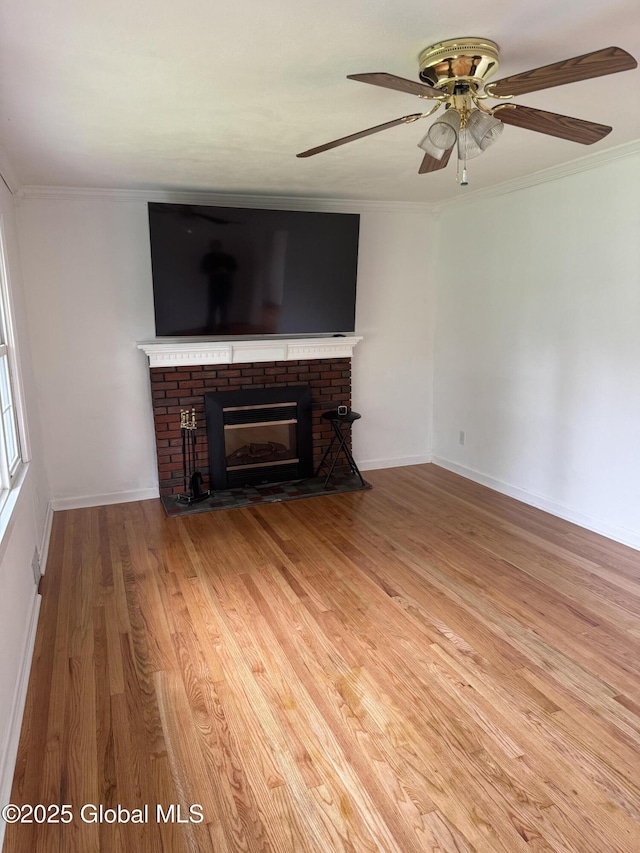 19 Callaghan Blvd, Charlton, NY 12019 - unfurnished living room featuring a brick fireplace, wood finished floors, ornamental molding, ceiling fan, and baseboards