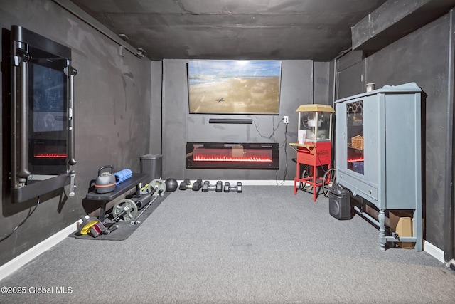 interior space featuring a glass covered fireplace, carpet floors, and baseboards