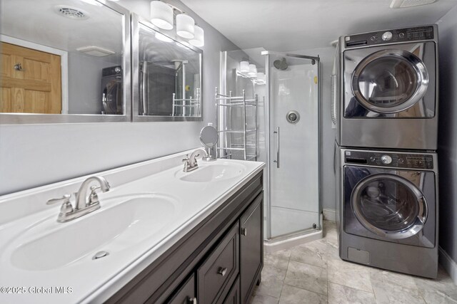 bathroom featuring stacked washer and clothes dryer, a sink, and a shower stall