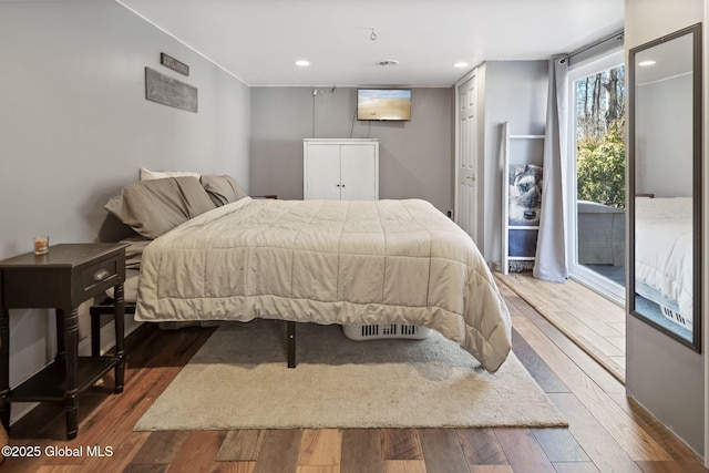 bedroom with wood finished floors, recessed lighting, and access to exterior