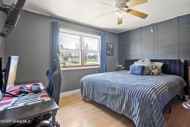 bedroom featuring wood finished floors, a ceiling fan, and baseboards