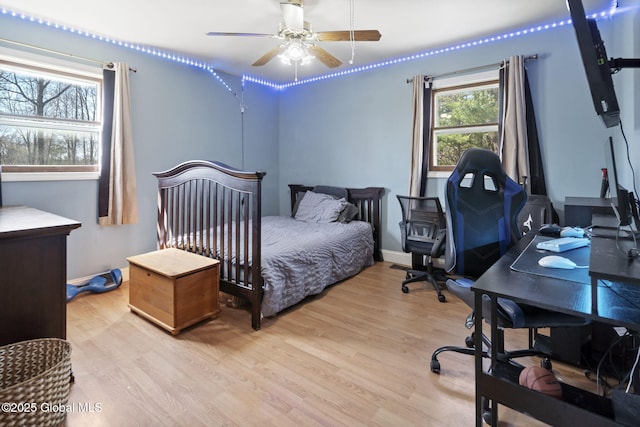 bedroom featuring baseboards, a ceiling fan, and wood finished floors