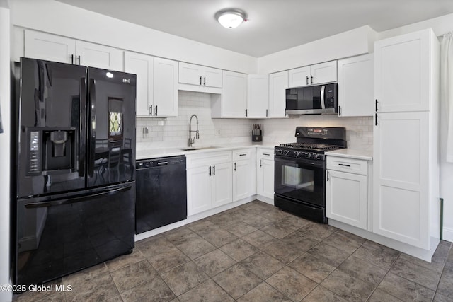 kitchen with light countertops, white cabinetry, a sink, and black appliances