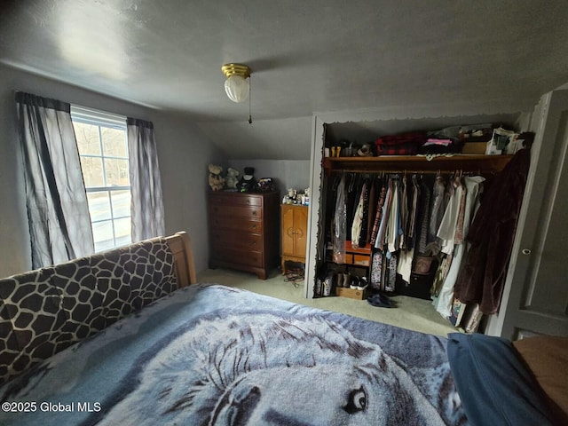 bedroom with a closet, ceiling fan, vaulted ceiling, and carpet floors