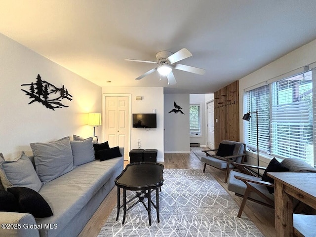 living room with a ceiling fan, baseboards, a healthy amount of sunlight, and wood finished floors