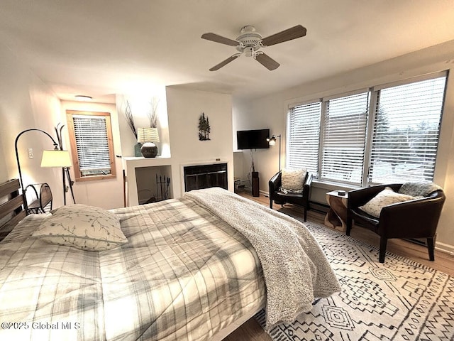 bedroom with light wood-type flooring, baseboards, and ceiling fan