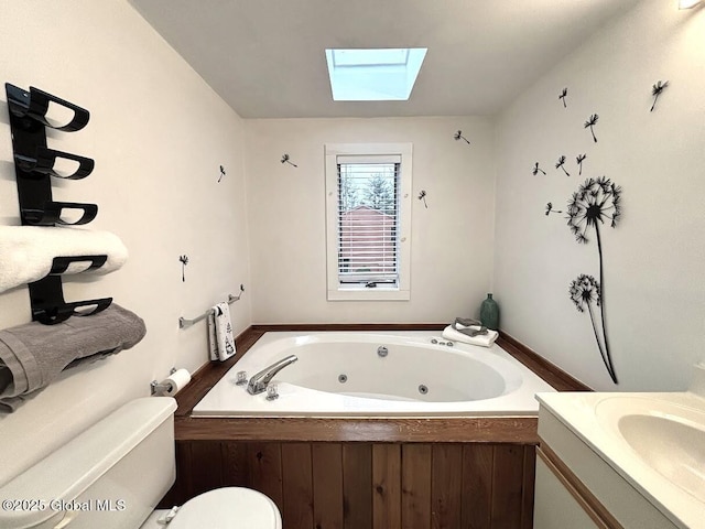full bathroom with a skylight, a whirlpool tub, vanity, and toilet