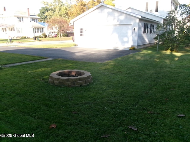 401 S 1st St, Northville, NY 12134 - view of property exterior featuring an attached garage, a yard, and an outdoor fire pit