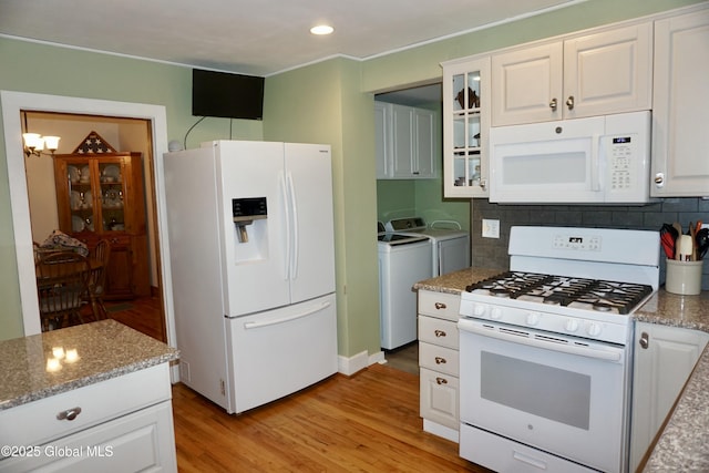 401 S 1st St, Northville, NY 12134 - kitchen featuring white cabinets, light wood-style flooring, backsplash, separate washer and dryer, and white appliances