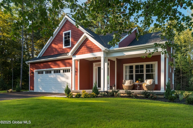 craftsman-style house featuring a porch, a front yard, and aphalt driveway
