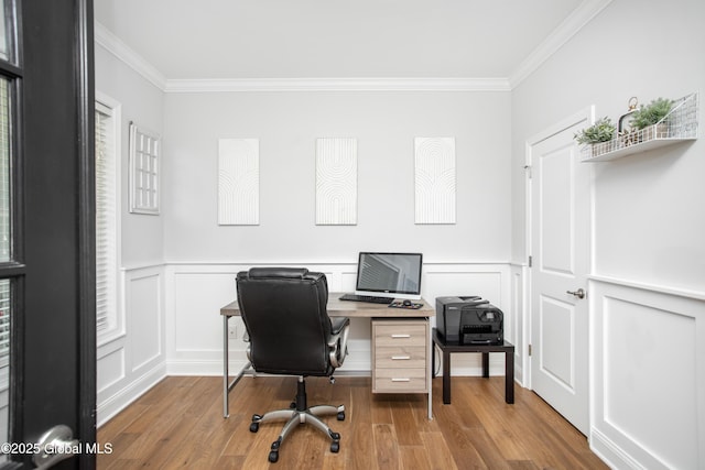 office featuring ornamental molding, a decorative wall, and wood finished floors
