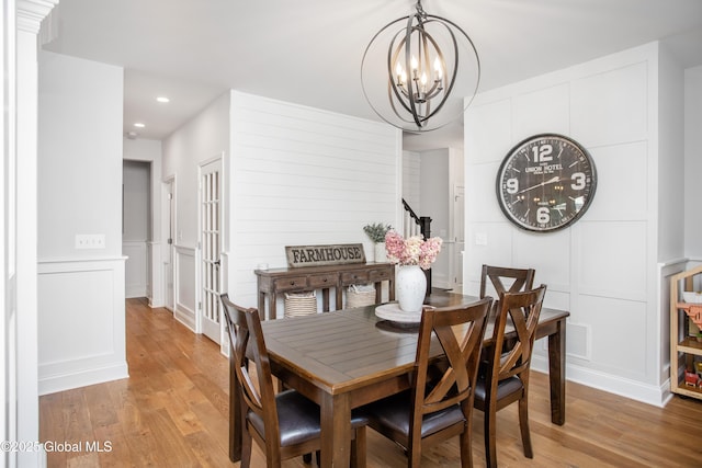 dining space featuring a decorative wall, a chandelier, recessed lighting, light wood-type flooring, and visible vents