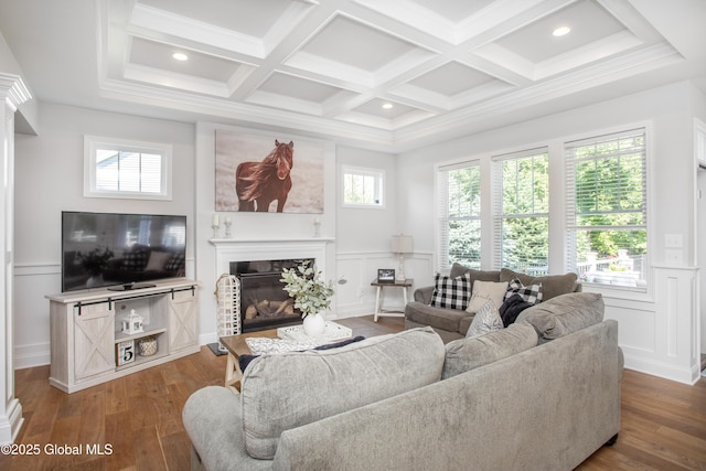 living area featuring a fireplace, coffered ceiling, wood finished floors, and a decorative wall