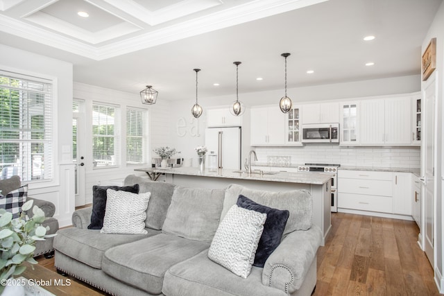 living room featuring recessed lighting, ornamental molding, a healthy amount of sunlight, and wood finished floors