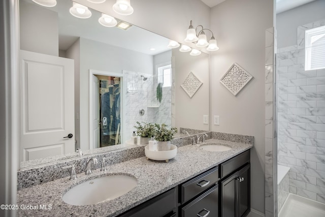 full bathroom with double vanity, a sink, a chandelier, and tiled shower