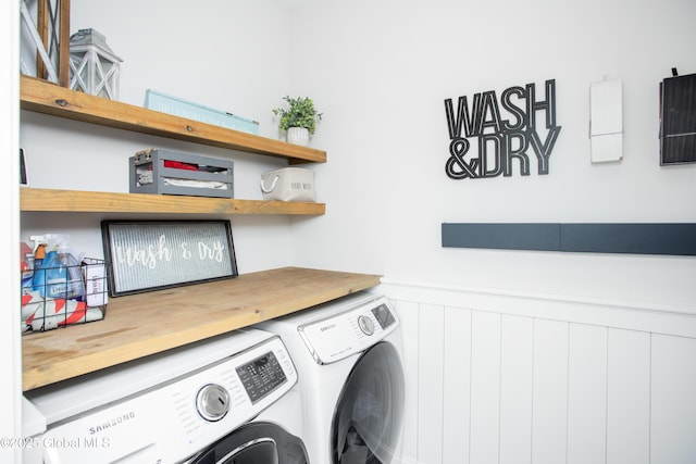 washroom with laundry area, a wainscoted wall, and washing machine and clothes dryer