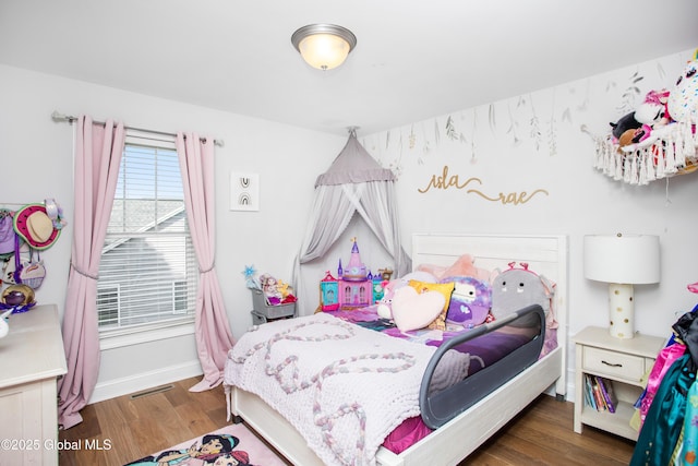 bedroom with visible vents, baseboards, and wood finished floors