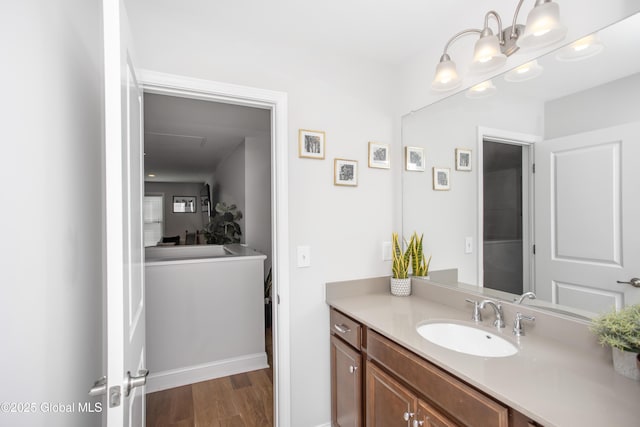 bathroom featuring baseboards, wood finished floors, and vanity