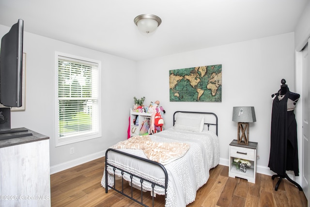 bedroom featuring baseboards and wood finished floors