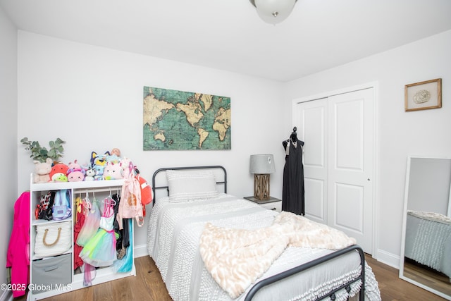 bedroom with a closet, baseboards, and wood finished floors