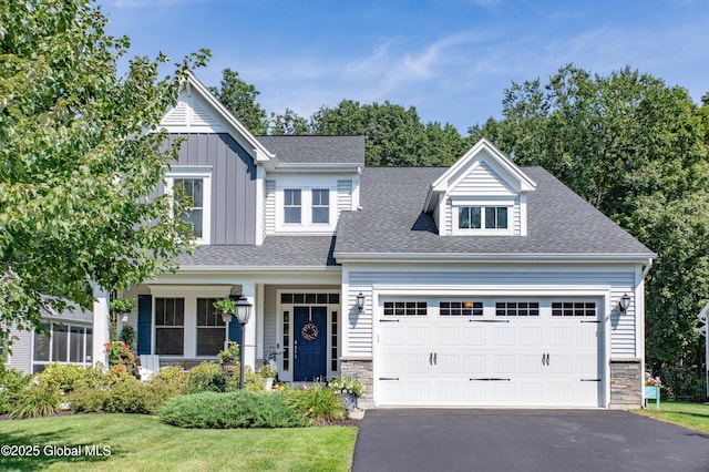 view of front of home featuring a garage, driveway, roof with shingles, and stone siding