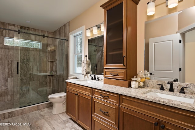 full bath featuring toilet, a stall shower, and a sink