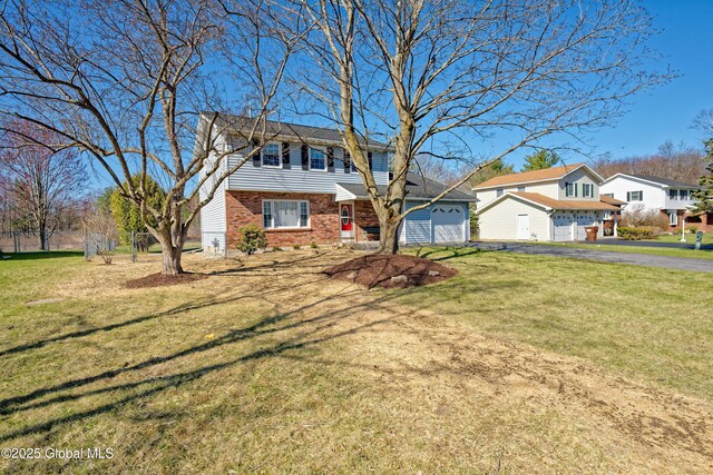 87 Dorchester Ave, Bethlehem, NY 12158 - view of front facade featuring a front lawn, aphalt driveway, fence, a garage, and brick siding
