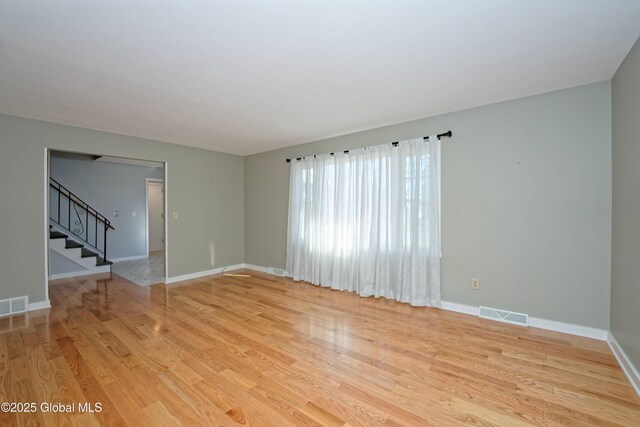 87 Dorchester Ave, Bethlehem, NY 12158 - unfurnished living room featuring light wood-type flooring, baseboards, visible vents, and stairway
