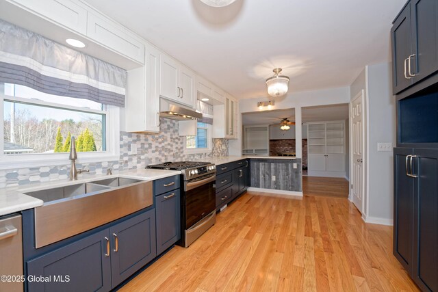 87 Dorchester Ave, Bethlehem, NY 12158 - kitchen featuring white cabinets, stainless steel appliances, light countertops, backsplash, and under cabinet range hood