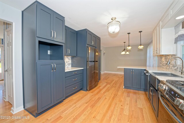 87 Dorchester Ave, Bethlehem, NY 12158 - kitchen with a peninsula, light wood-style flooring, tasteful backsplash, baseboards, and appliances with stainless steel finishes