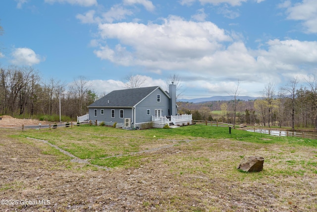 214 Vosenkill Rd, Athens, NY 12015 - view of side of property featuring a wooden deck, a chimney, roof with shingles, a lawn, and fence
