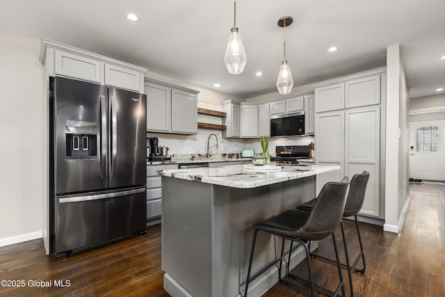 214 Vosenkill Rd, Athens, NY 12015 - kitchen featuring light stone countertops, dark wood-style flooring, stainless steel appliances, a kitchen island, and baseboards