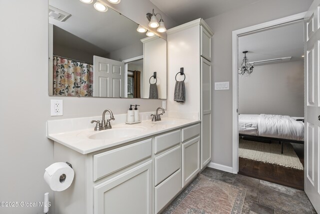 214 Vosenkill Rd, Athens, NY 12015 - ensuite bathroom with double vanity, a sink, stone finish floor, and visible vents