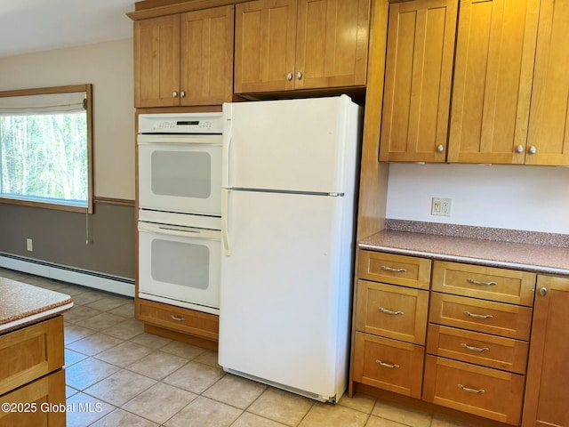 kitchen featuring light tile patterned floors, white appliances, brown cabinets, and a baseboard heating unit