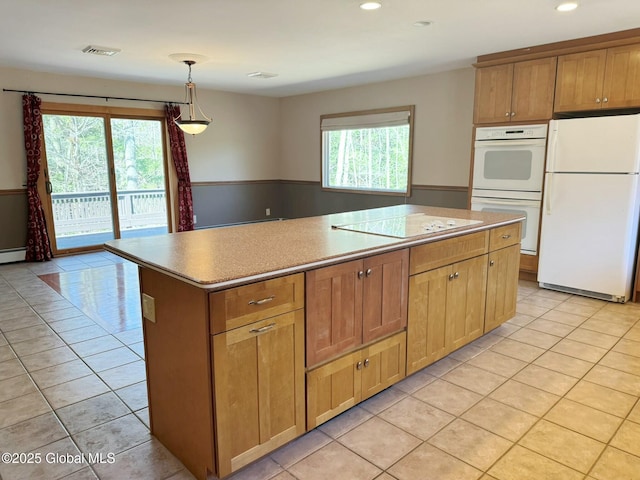 kitchen with light tile patterned floors, white appliances, a kitchen island, and recessed lighting